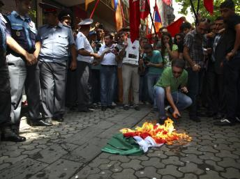 Exemple de « dégradation d’un symbole » où un drapeau est brûlé lors d’une manifestation. Image issue de Wikimedia Commons. 
